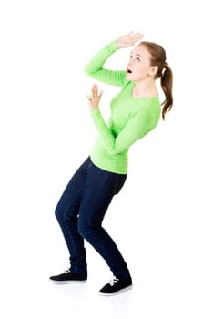 scared young woman afraid of something above her,isolated on white