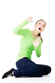 scared young woman afraid of something above her,isolated on white