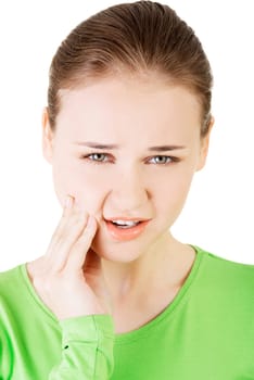 teen woman pressing her bruised cheek with a painful expression as if she's having a terrible tooth ache.