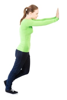 Woman pushing something imaginary isolated over a white background (white wall over her hands)
