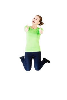 young happy caucasian woman jumping in the air with thumbs up,isolated on white background