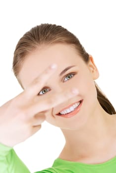 Happy young teen girl showing victory sign isolated on white background