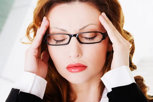 businesswoman with a headache holding head