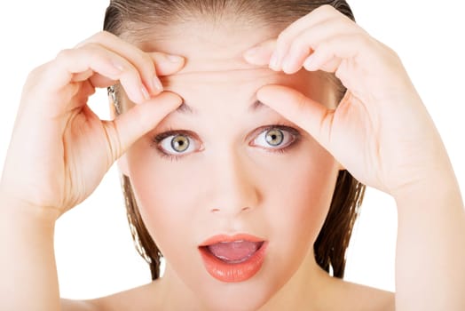 woman checking her wrinkles on her forehead - isolated on white