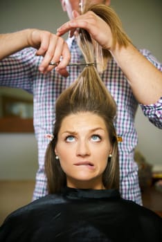 female client in hairdresser shop uncertain about cutting hair and biting lips