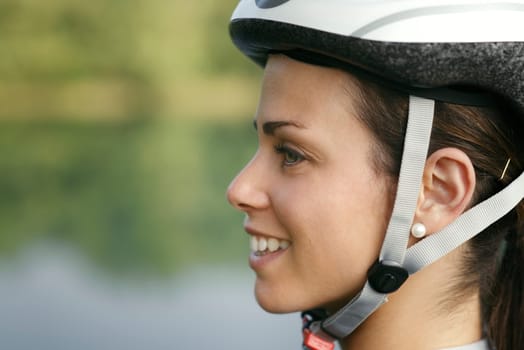 portrait of young woman training on mountain bike and smiling looking at view on lake