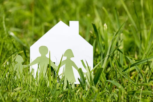Paper cut of family with house  in a  green grass