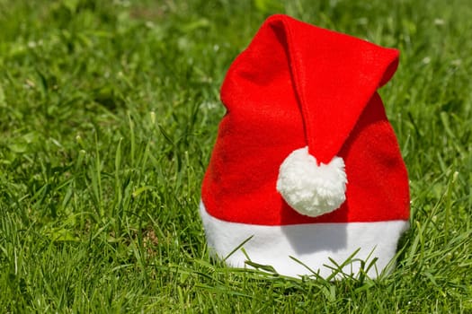 Red Santa's hat on the green grass