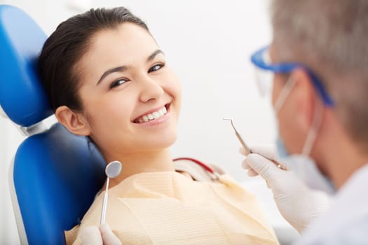 Image of smiling patient looking at camera at the dentist’s