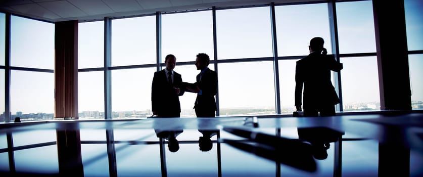 Business people spending a usual busy day in office, only silhouettes being recognizable