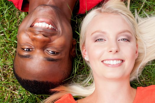 Young in love multicultural couple on a meadow in summer leisure fun