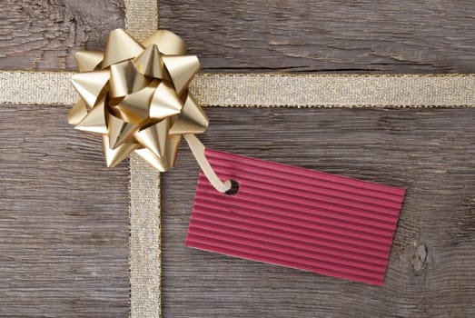 a red tag with hcopy space hanging on a golden bow