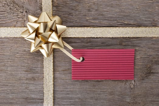 a golden bow with a red label with copy space as background