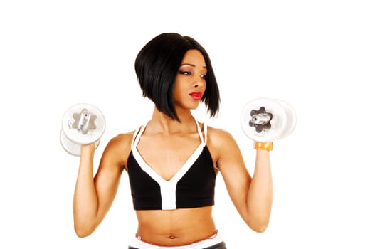 A slim young woman in black exercise clothing working out with silver.color dumbbells for white background..