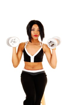A slim young woman in black exercise clothing working out with silver.color dumbbells for white background..