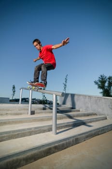 Skateboarder on a grind at the local skatepark.