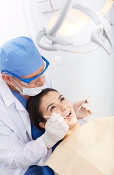 Young girl with open mouth during oral checkup at the dentist’s