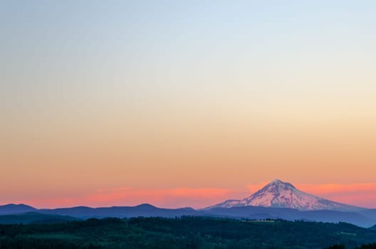 Mount Hood looking purple at sunset with sky taking up most of the frame