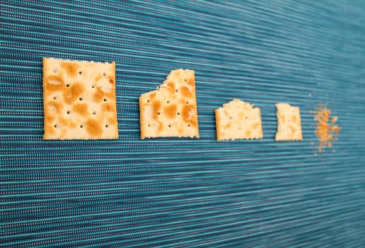 Salted crackers bitten process, background.