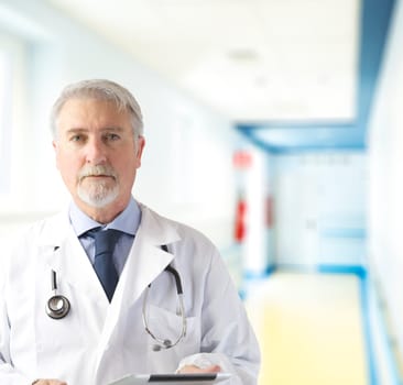Doctor in the hallway of the hospital with tablet in hand
