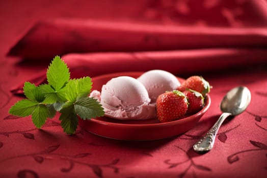 Strawberry ice cream on red background close up