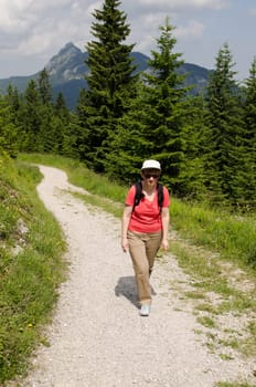 Female hiker in the Allgäu in front of trees and mountains