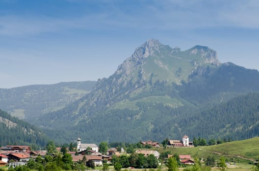 Village Grän with the mountain Aggenstein and blue sky