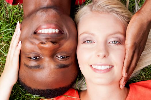 Young in love multicultural couple on a meadow in summer leisure fun