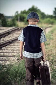 Boy with suitcase at the train station