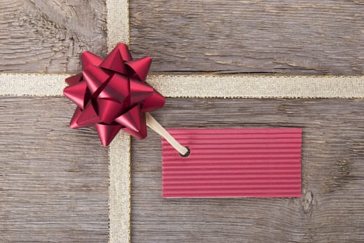 a red ticket with copy space hanging on a bow as gift background