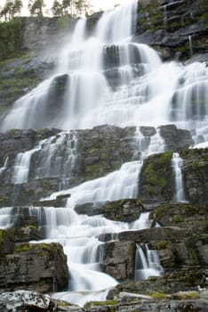 a waterfall in norway, water running down stones in cascades