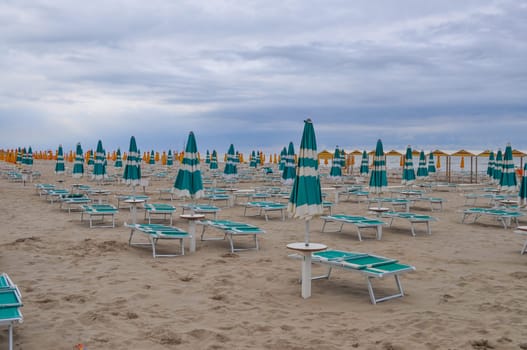 Shore beach with sun umbrella and deckchairs