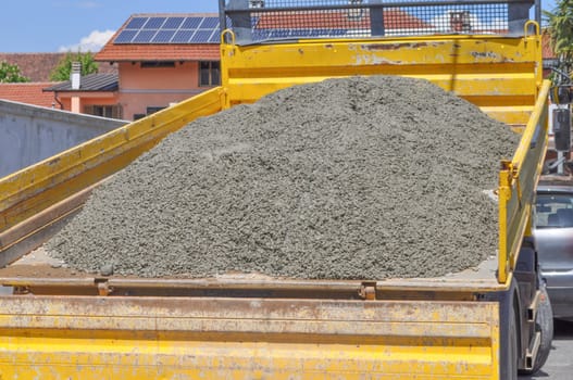 Yellow lorry transporting concrete to road works construction site