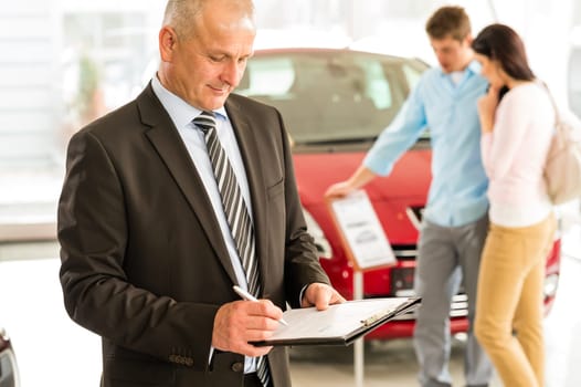 Portrait of Caucasian salesman in car showroom