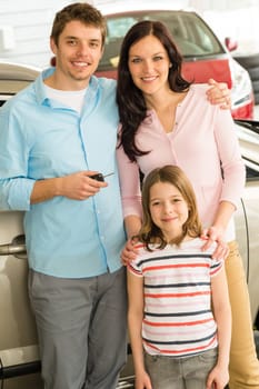 Portrait of young caucasian family with new car