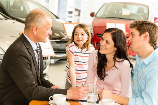 Car salesman and caucasian couple doing paperwork