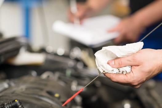 Closeup of the hand of car mechanic checking oil