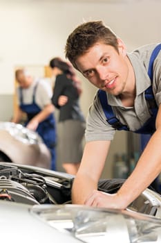 Portrait of young mechanic repairing car