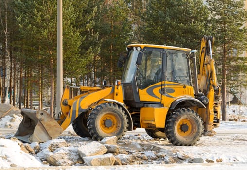 Orange snowblower on a background of trees