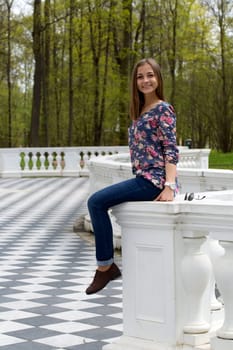 girl sitting on the railing in the park