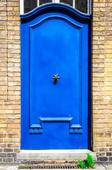 Closed blue entrance door in brick wall