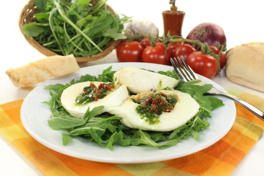 stuffed mozzarella on a bed of rocket against a white background