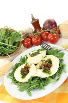stuffed mozzarella on a bed of rocket against a white background