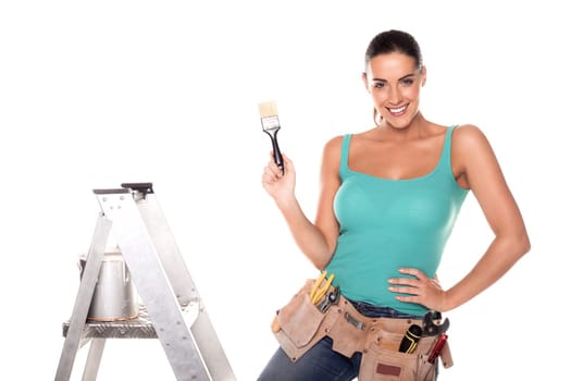 A woman wearing a DIY tool belt full of a variety of useful tools on a white background.