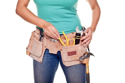 A woman wearing a DIY tool belt full of a variety of useful tools on a white background.