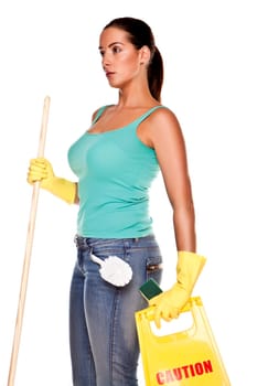 An attractive young woman with brunet hair wearing a blue vest top and yellow rubber cleaning gloves and doing some cleaning on a white background .