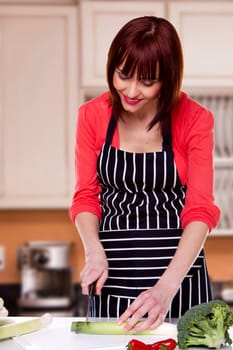 Beautiful housewife chopping vegetables to make a delicious meal.