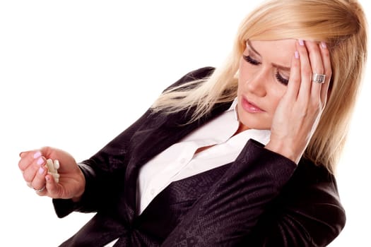 A stressful businesswoman with a migraine holding painkillers.