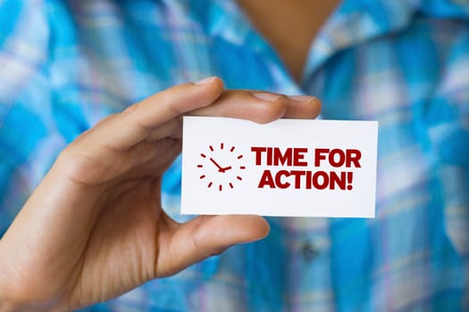 A person holding a white card with the words Time For Action