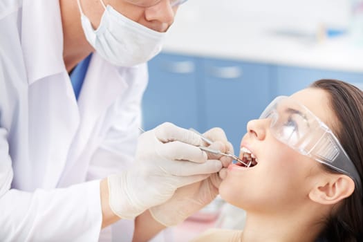 Young girl with open mouth during oral checkup at the dentist’s